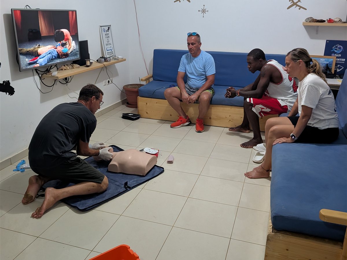 Group first-aid class with oxygen kit and CPR manikin